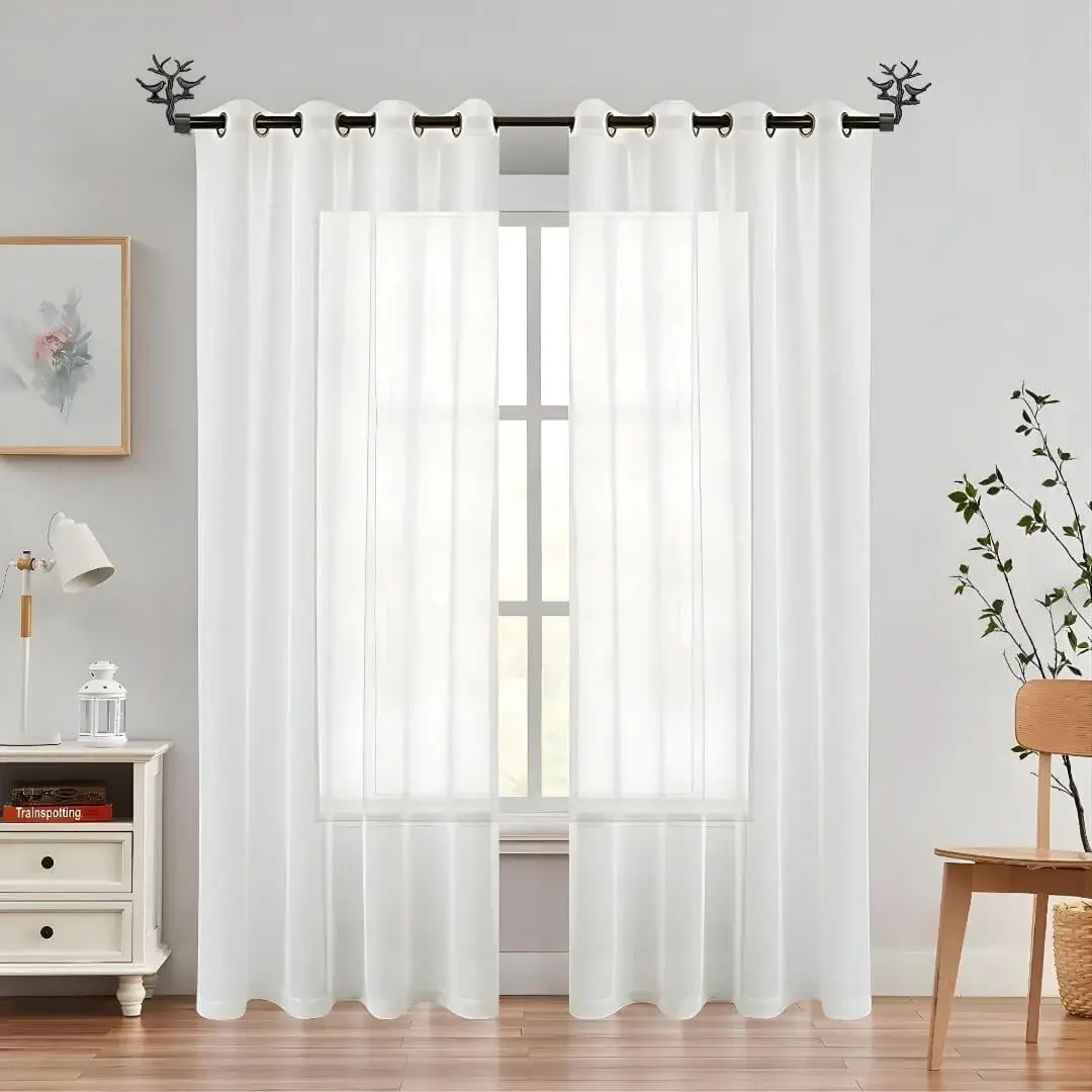 Elegant floor-length white sheer curtains gracefully hanging from sleek black curtain rods with bird finials, creating a modern and sophisticated window treatment