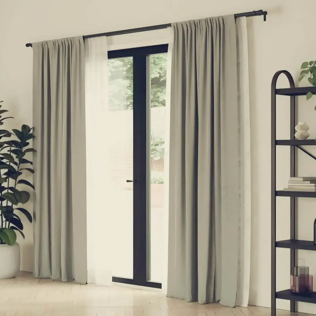 Elegant floor-length curtains gracefully hanging from sleek black curtain rods installed on a sliding glass door, creating a modern and sophisticated window treatment