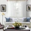 curtains for home Stylish living room with flowing curtains on a 12 feet long gold curtain rod, paired with a cozy sofa set, vibrant cushions, and wall paintings—creating a chic, inviting ambiance.