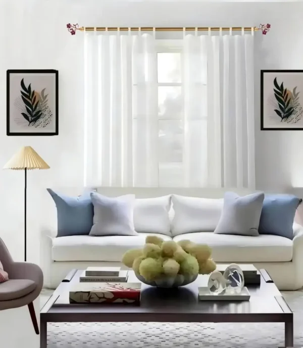 Stylish living room with flowing curtains on a 12 feet long gold curtain rod, paired with a cozy sofa set, vibrant cushions, and wall paintings—creating a chic, inviting ambiance.