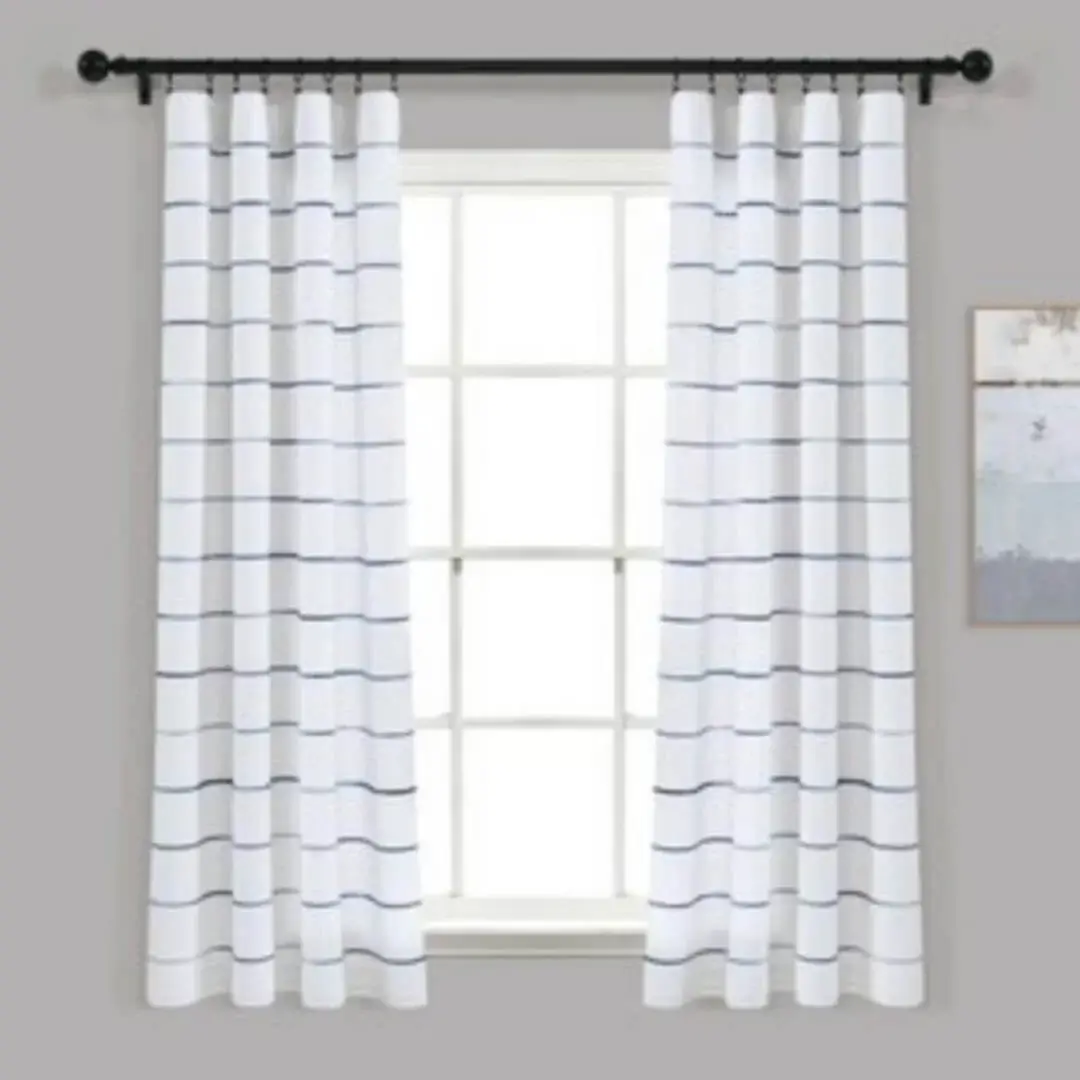 Elegant checks curtain gracefully hanging from a sleek black curtain rod installed on a small window, creating an airy and sophisticated look