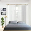 gold curtain rod for bedroom Elegant sheer curtains cascading from a luxurious gold curtain rod in a stylish bedroom, featuring a cot, wall painting, side lamp, and potted plant—creating a bright, airy, and sophisticated ambiance