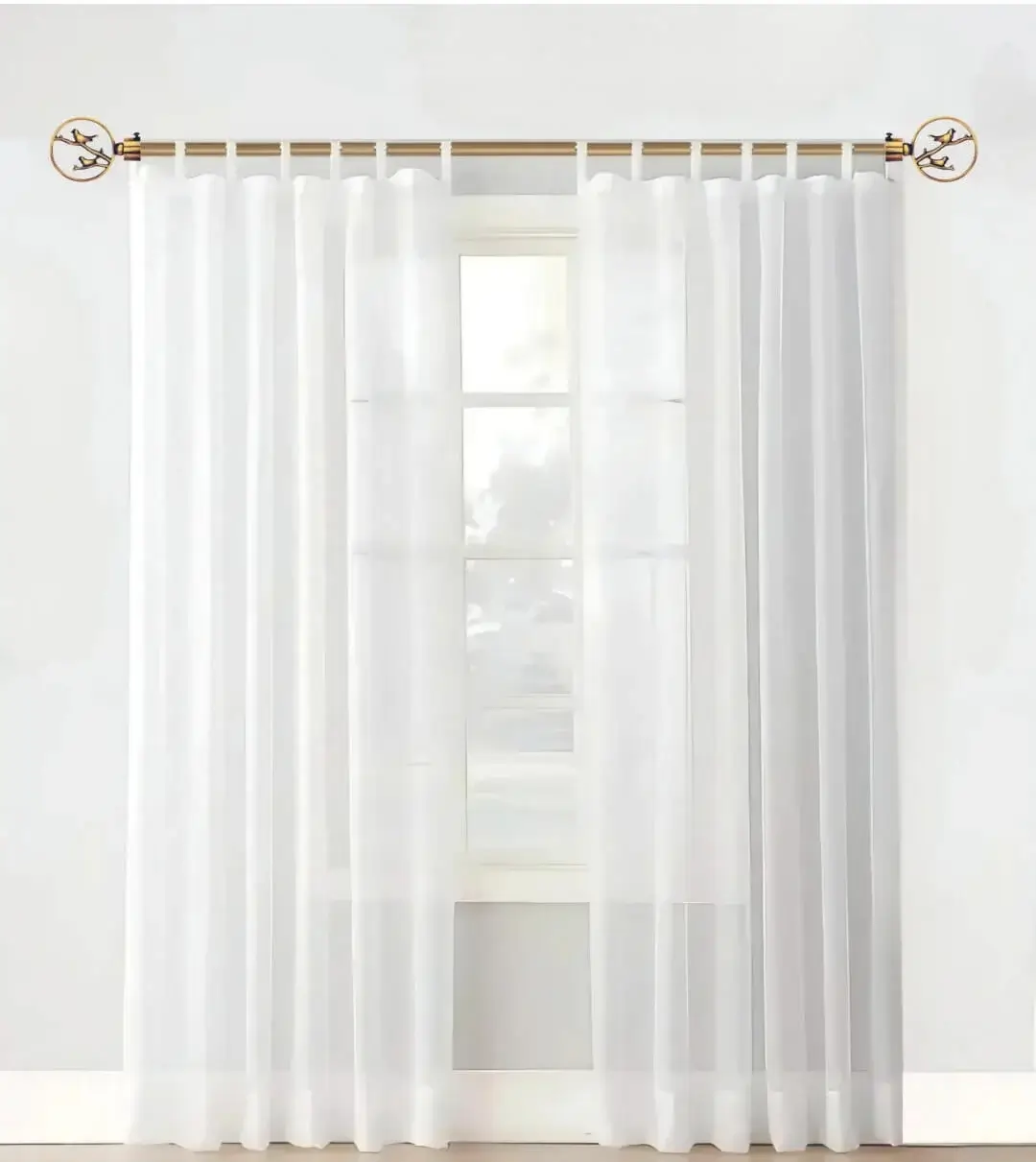 Elegant sheer curtain gracefully hanging from a sleek gold curtain rod with bird finial installed on a small window, creating an airy and sophisticated look