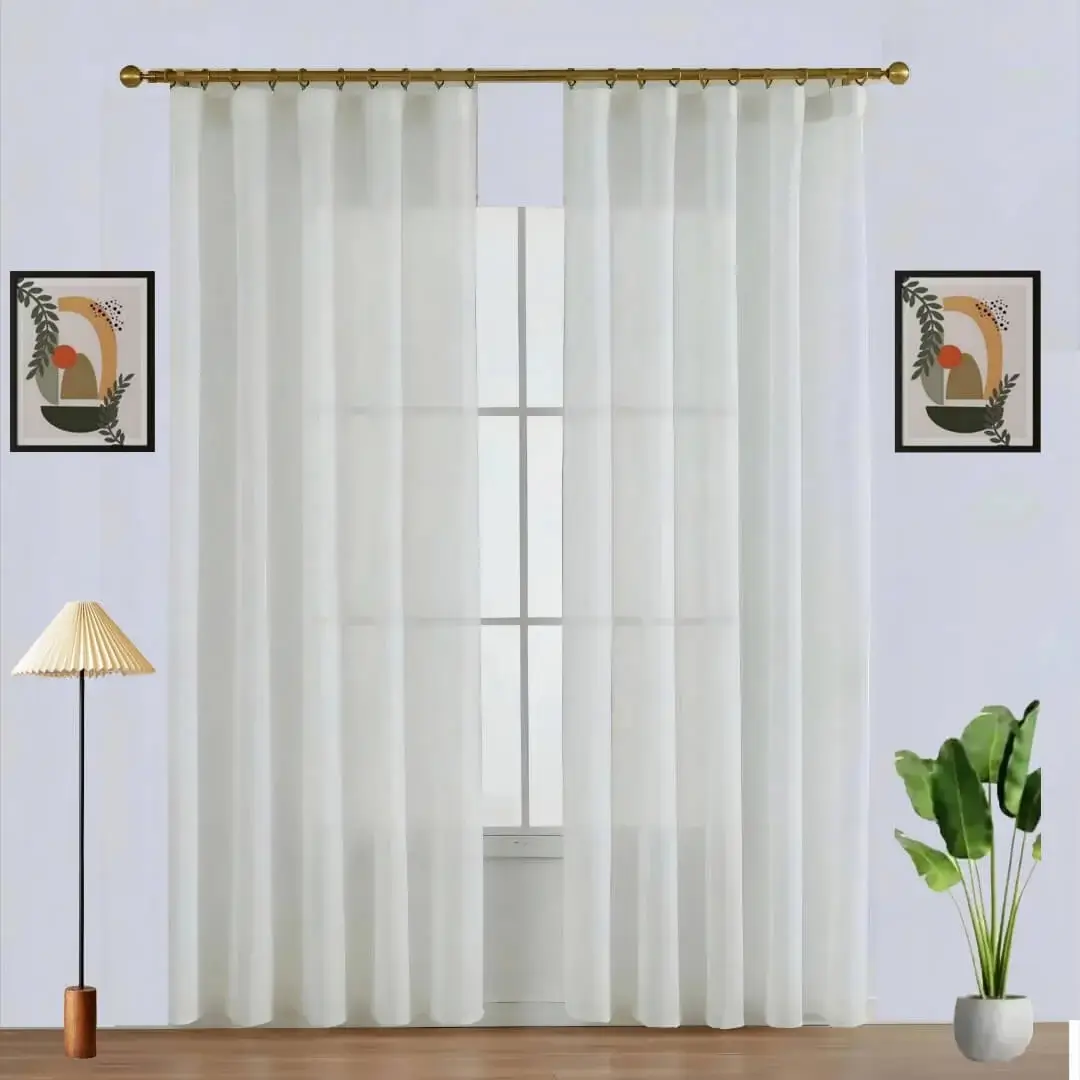 Elegant sheer curtain gracefully hanging from a luxurious gold curtain rod with ball finial installed on a window, creating an airy and sophisticated look