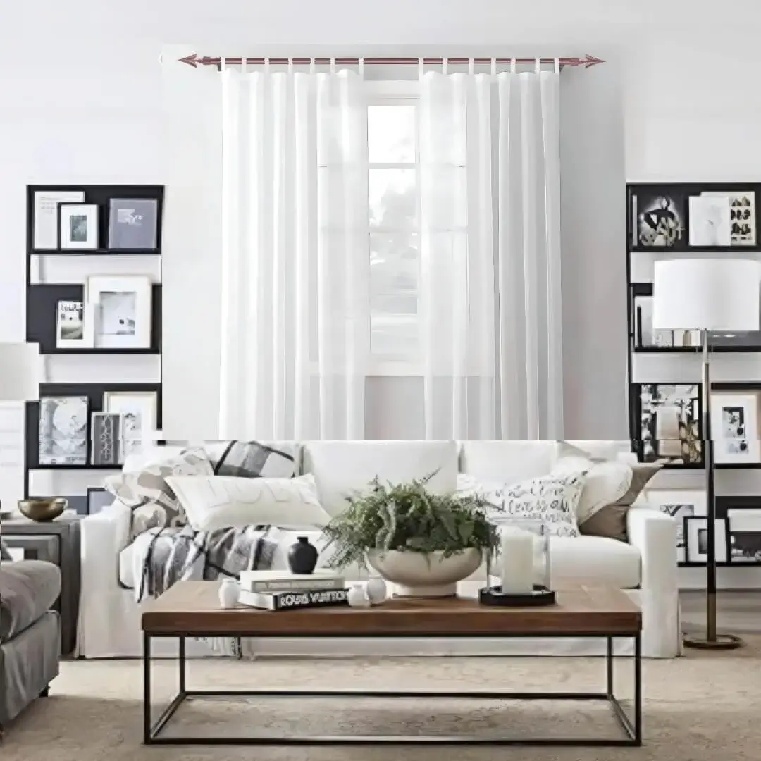 Stylish living room with flowing net curtains on a rose gold curtain rod, paired with a cozy sofa set, nice cushions, and wall paintings—creating a chic, inviting ambiance