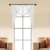 valance curtain Elegant sheer valance curtain gracefully hanging from a sleek black curtain rod installed on a small window, creating an airy and sophisticated look