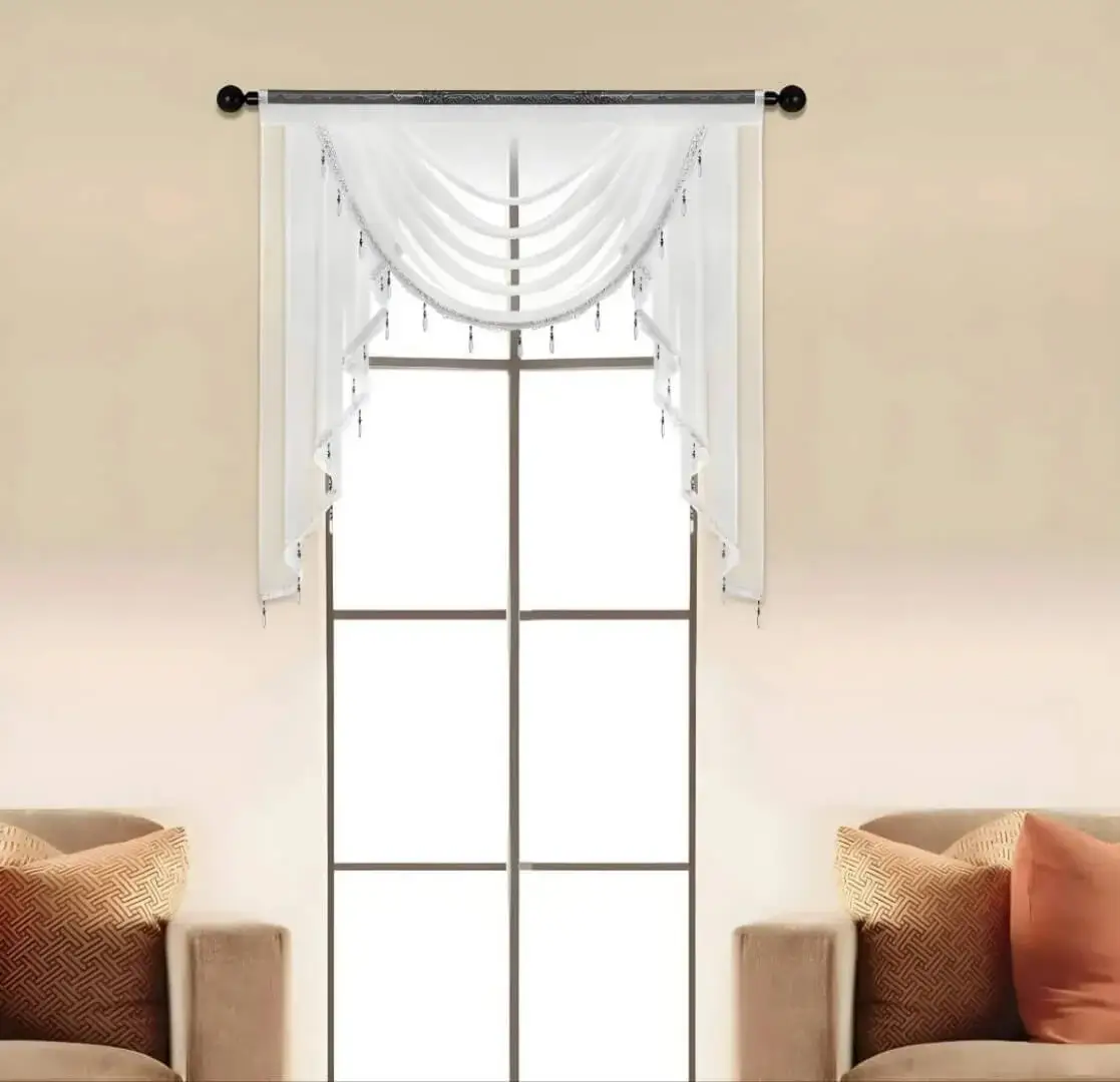 Elegant sheer valance curtain gracefully hanging from a sleek black curtain rod installed on a small window, creating an airy and sophisticated look
